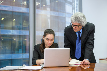 Mature businessman helping a young employee
