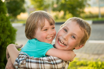 Fototapeta na wymiar Boy and girl hugging. Green meadow. Funny kids.