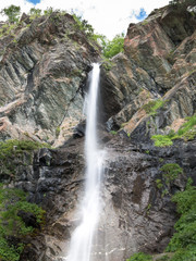 Mountain landscape with a waterfall in the background of the sky with trees