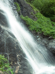 Toned image of flowing water on a background of grass