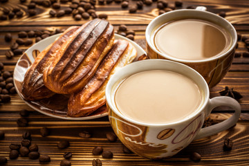 Coffee with cake on brown wooden table. Coffee with milk.