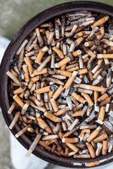 Cigarettes butts stacked on circular ashtrays