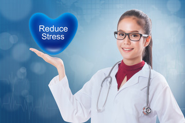 Female doctor holding heart with reduce stress sign on medical background.