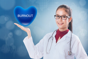 Female doctor holding heart with burnout sign on medical background.