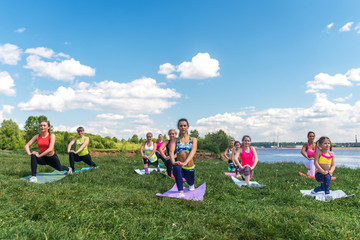 Group of women exercising and doing lunge at boot camp.