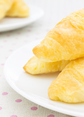 Croissant or Bread on White Dish on placemat Close up Portrait View