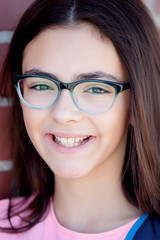 Obraz premium Preteenager girl next to a red brick wall