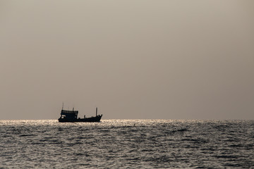 Silhouette boat and sunset over the sea water