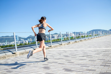 Woman using smart watch and running in a city