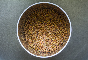 buckwheat in metal tin close-up on black background