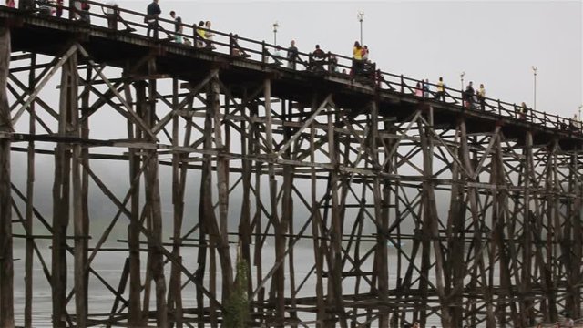 SANGKHLABURI, THAILAND - DECEMBER 27, 2015: Traveler crowd walking on Sapan Mon Bridge, wooden bridge across the river in morning in Sangkhlaburi District, Kanchanaburi Thailand,on December 27, 2015