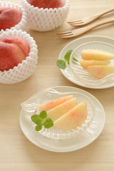 桃3個とカットした桃　木目背景

