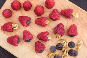 Red raspberries, walnuts, and chocolate chips laid out to make a tasty treat
