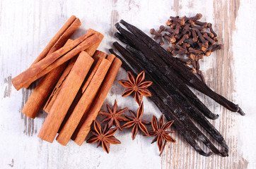 Cinnamon sticks, vanilla, star anise and cloves on wooden surface