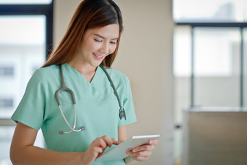 Young doctor woman smile face with stethoscope looking tablet computer. showing blank area for sign or copyspace