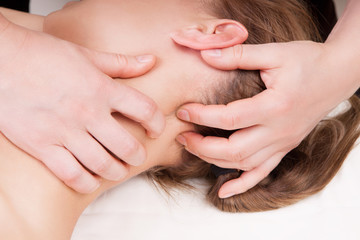 A woman getting a stress relieving pressure point massage on her neck by a therapist