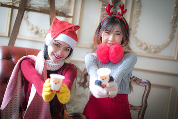 Two beautiful elegant women in winter clothing And hot drinks.