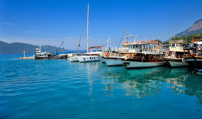 Fototapeta na wymiar Sea pier with colorful boats. Aegean sea. Turkey