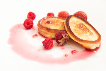 Two muffin on a white plate in raspberry syrup