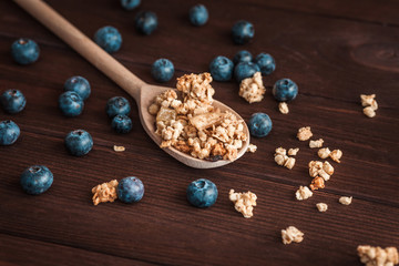 muesli with blueberries on a wooden spoon