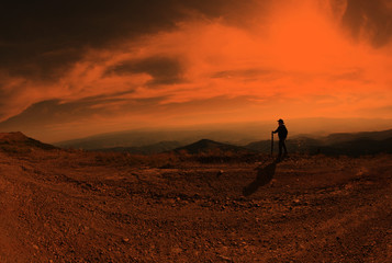 Boy is hiking on beautiful mountain sunset