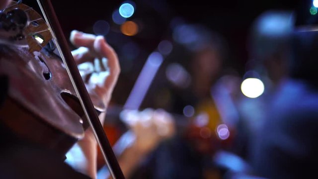 Concert, a musician hand playing the violin, close up shot