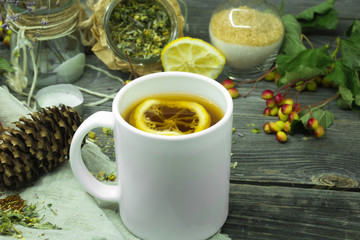 the Cup of tea on a beautiful wooden background with lemon and herbs, winter ,autumn