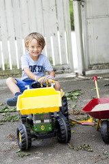 Kleiner Junge auf seinem Spielzeug Traktor