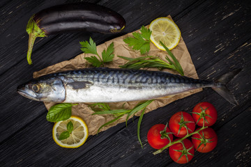 Mackerels served on parchment with lemon, tomatoes, eggplant, and herbs