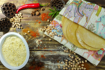 Colorful Indian food  - chickpea, papadum and spices on textured