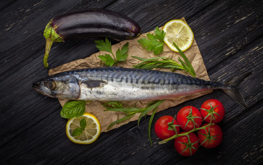 Mackerels served on parchment with lemon, tomatoes, eggplant, and herbs