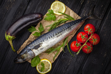 Mackerels served on parchment with lemon, tomatoes, eggplant, and herbs