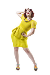 Young beautiful red-haired caucasian woman in yellow dress posing in studio, isolated on white background, professional makeup and hairstyle