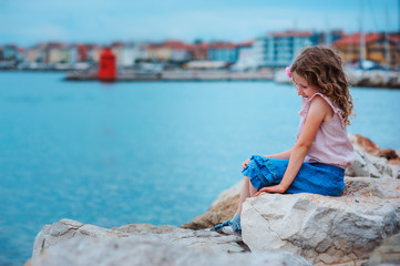 adorable dreamy child girl relaxing on the beach in Piran, Slovenia