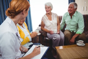 Obraz premium Seniors peoples and nurse seated in a sofa