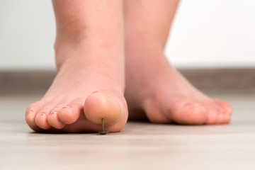 Female foot above pushpin