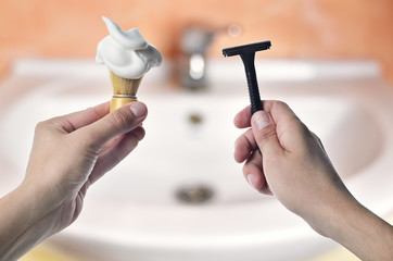 Razor and brush for shaving foam in hand
