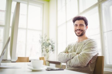 Smiling businessman sitting at desk in office