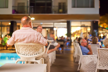 Old man sitting back side on chair