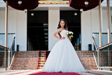 Portrait of beautiful sensual young bride at wedding hall on red