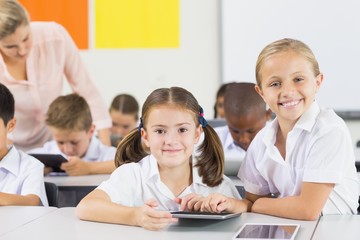 School kids using digital tablet in classroom