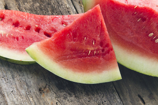 pieces of watermelon on wooden background.