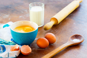 Cooking supplies and ingredients on vintage wooden table.