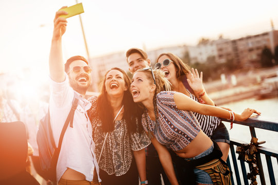 Friends taking selfies and smiling