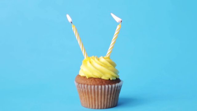 birthday cupcake with two burning candles