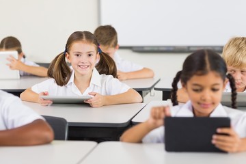 Schoolgirl using digital tablet in classroom