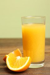 a glass of orange juice on a brown wooden background