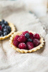 baskets of pastry with fresh berries on plate.