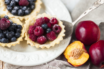 baskets of pastry with fresh berries on plate.