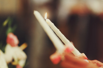 White candles burn during a wedding ceremony